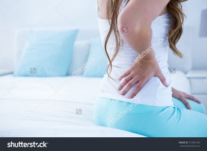 stock-photo-attractive-woman-with-back-pain-at-home-in-the-bedroom-273587345   